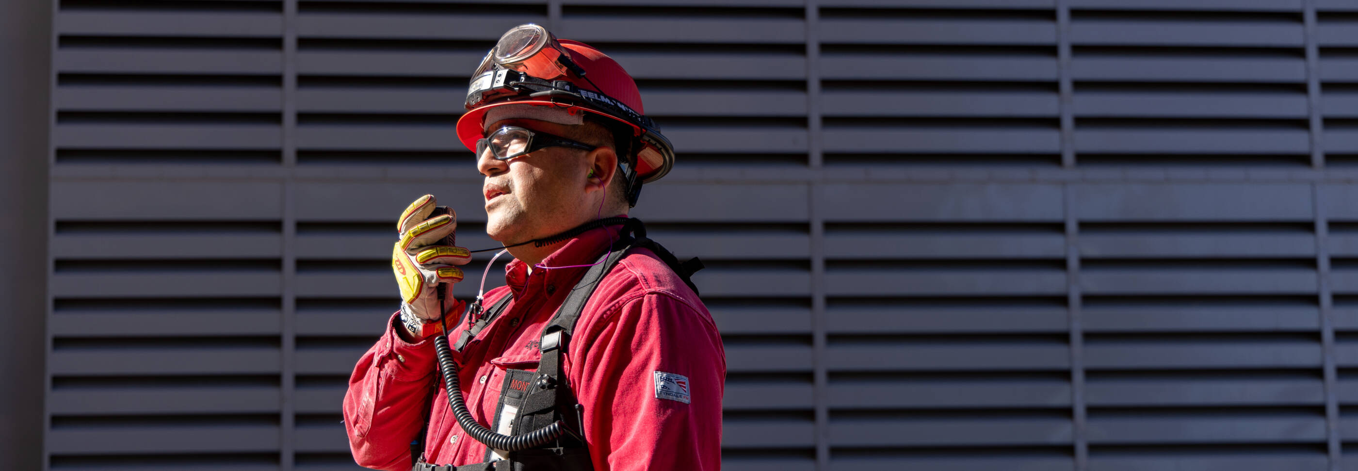 GCGV employee wearing red hard hat and walkie talkie.